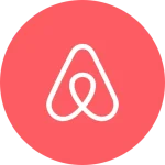 Airbnb logo featuring a stylized white outline on a red circular background.